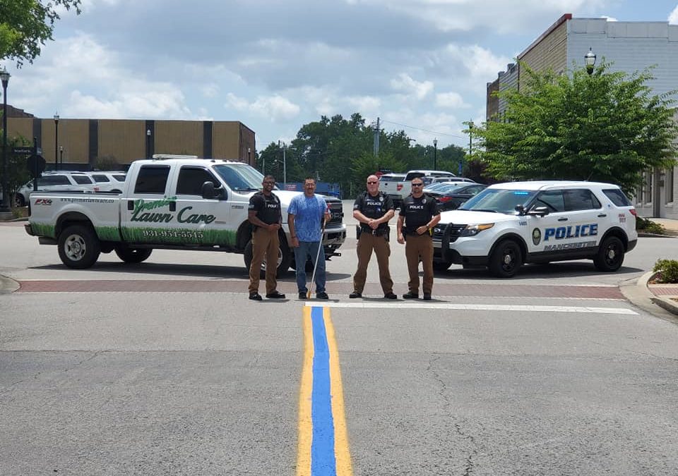 Premier Lawn Care paints blue line on N. Irwin St. in support of MPD